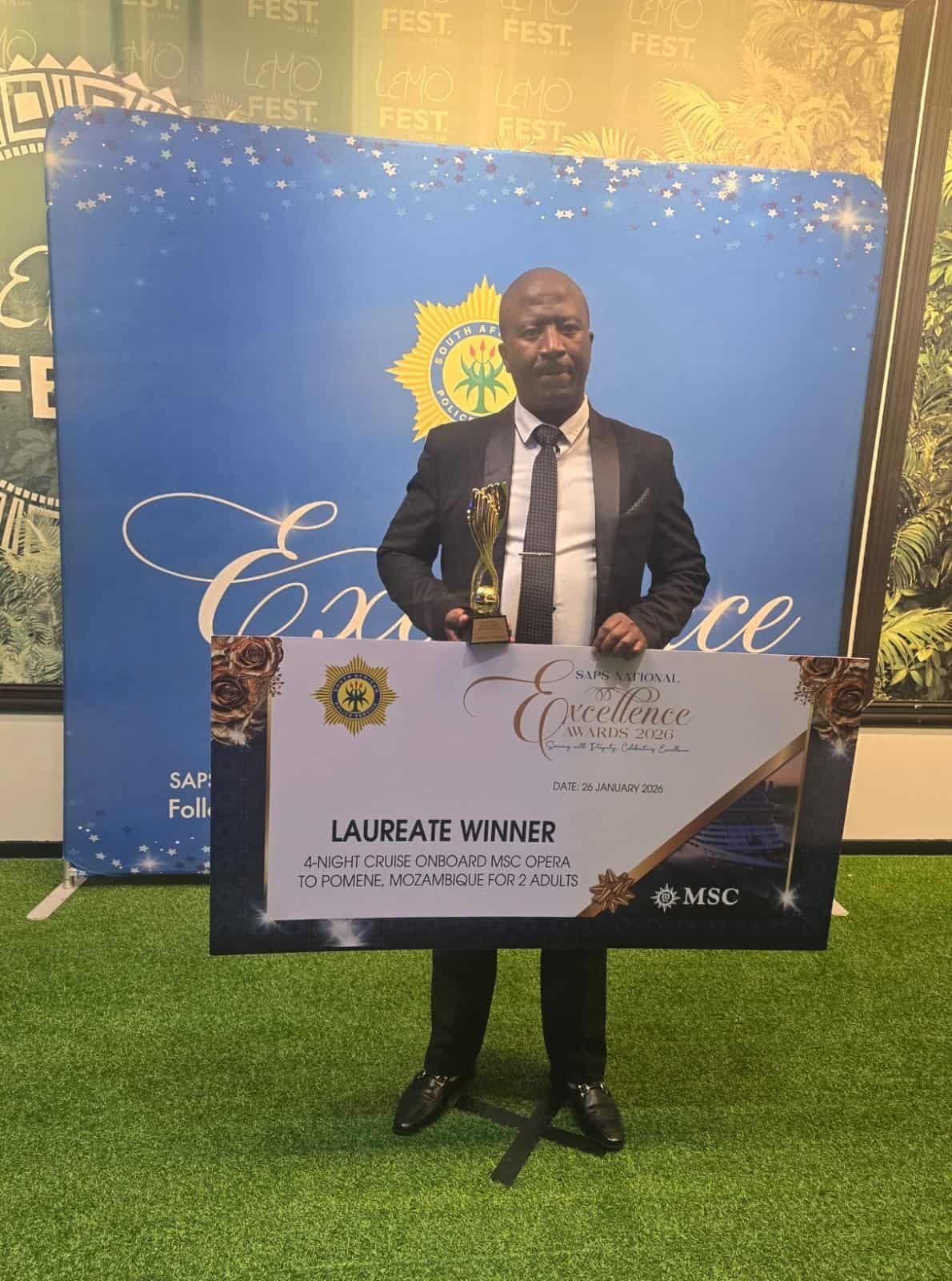 Sergeant Masibulele Qinisile holding trophy and certificate for excellence award in Africa.