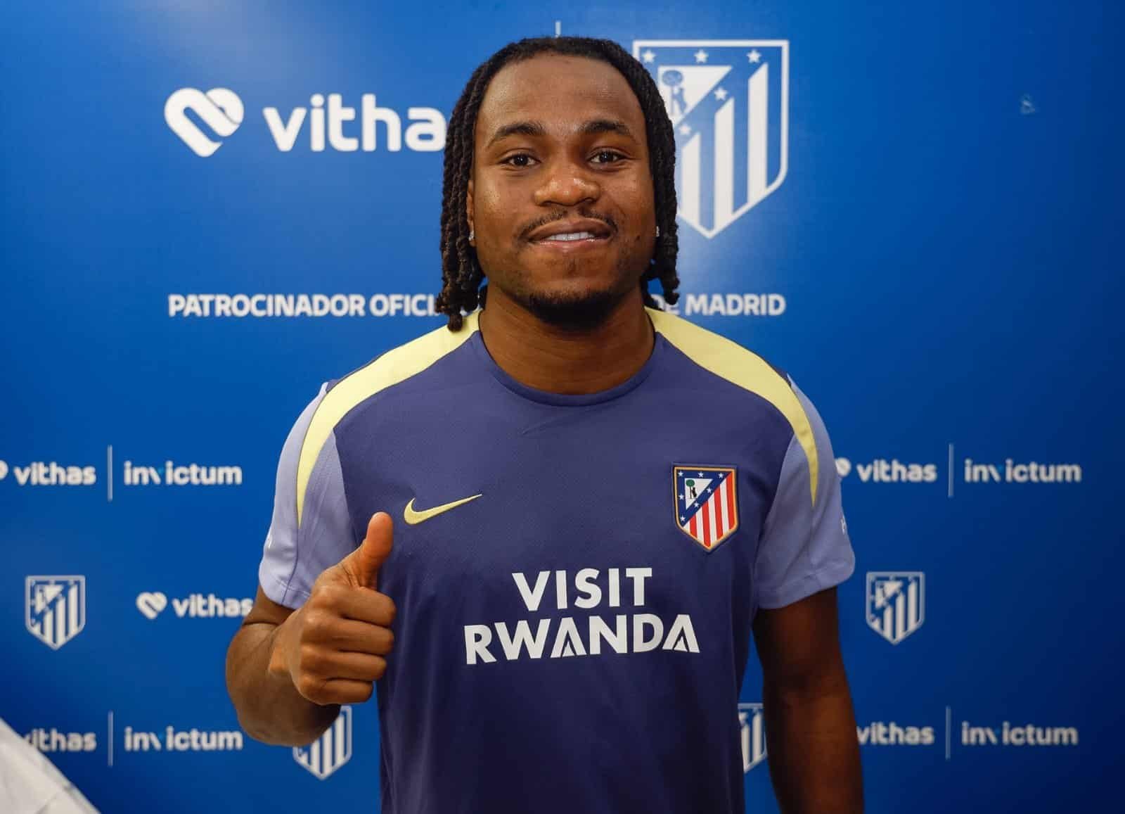 Ademola Lookman in Atlético Madrid jersey giving a thumbs-up at a press event.