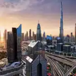 Dubai skyline with Burj Khalifa at sunset, featuring modern skyscrapers and city infrastructure.