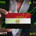 Businessperson analyzing stock market trends with Egyptian flag background.