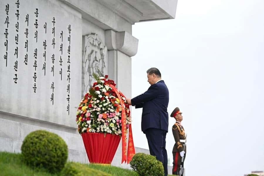 Xi Jinping, general secretary of the Communist Party of China Central Committee and Chinese president, straightens the ribbons on a flower basket while paying homage to the China-DPRK Friendship Tower with his wife Peng Liyuan, in the company of Kim Jong Un, general secretary of the Workers' Party of Korea and president of the State Affairs of the Democratic People's Republic of Korea (DPRK), and Kim's wife Ri Sol Ju, in Pyongyang, the DPRK, June 9, 2026.