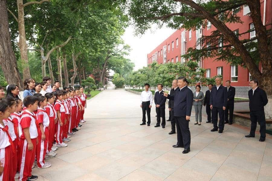 Chinese President Xi Jinping talks with students and teachers in a square of Beijing Yuying School
