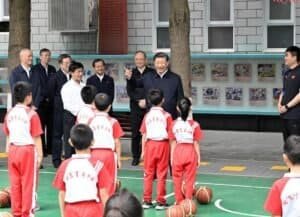 Chinese President Xi Jinping, also general secretary of the Communist Party of China Central Committee and chairman of the Central Military Commission, talks with students on the basketball court of Beijing Yuying School in Beijing