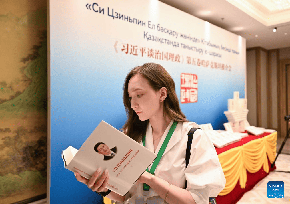 A journalist reads a copy of "Xi Jinping: The Governance of China" at an event promoting the fifth volume of the book in Astana, Kazakhstan, July 15, 2026. The event was held here on Wednesday. (Xinhua/Li Renzi)