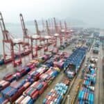 An aerial drone photo taken on July 14, 2026 shows cargo ships loading and unloading containers at a container terminal of Lianyungang Port, east China's Jiangsu Province. (Photo by Wang Chun/Xinhua)