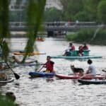 People enjoy paddleboarding on the Liangma River in Beijing, capital of China, June 23, 2023.