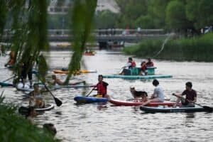 People enjoy paddleboarding on the Liangma River in Beijing, capital of China, June 23, 2023.