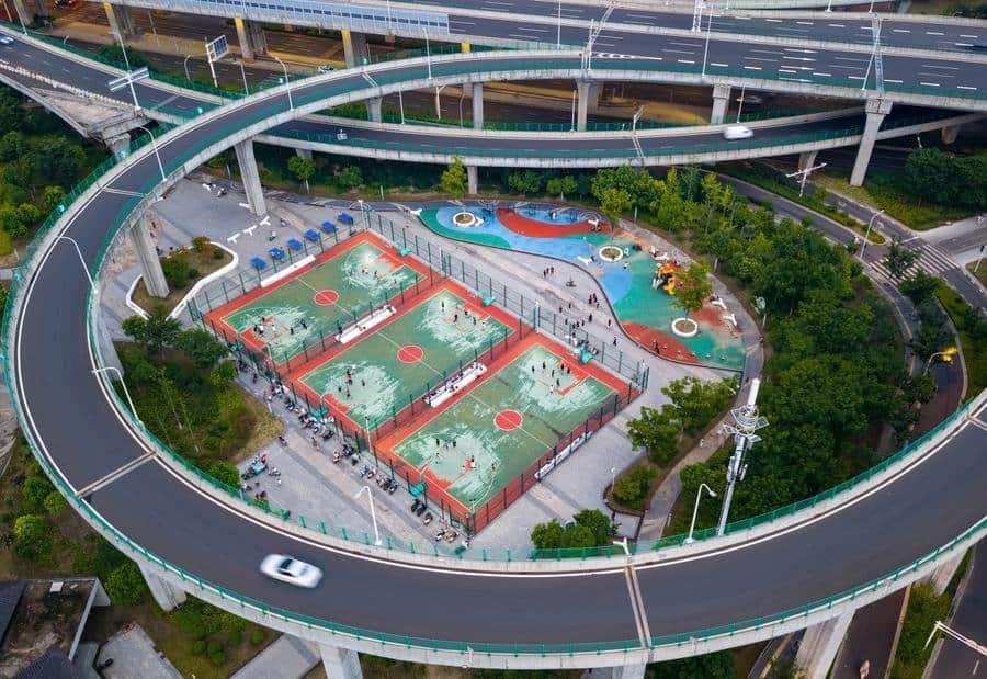An aerial drone photo taken on July 27, 2026 shows people exercising at a sports park beneath an overpass in Huaian, east China's Jiangsu Province. (Photo by He Jinghua/Xinhua)