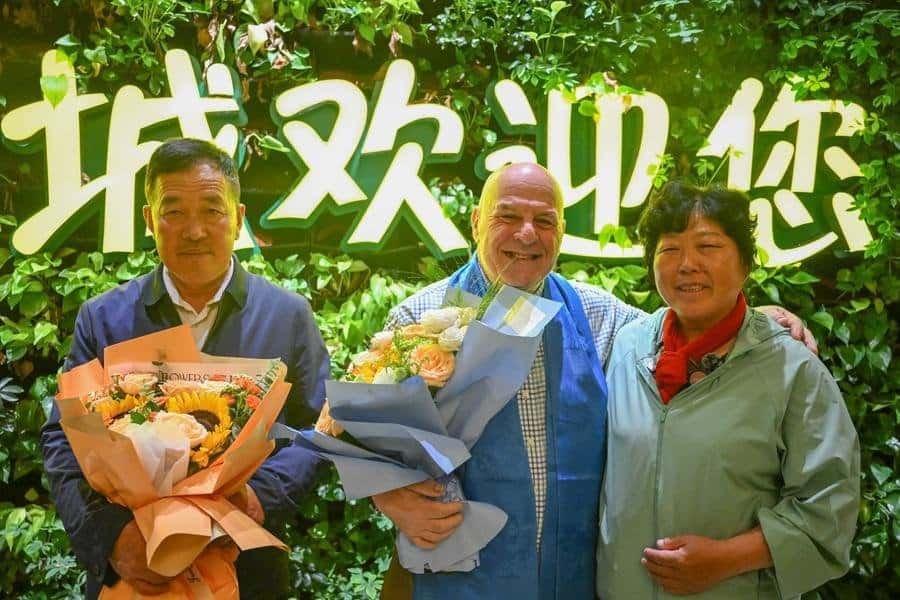 Ronald Sakolsky (C), Yin Yuzhen (R) and Yin's husband Bai Wanxiang pose for photos at an airport in Ordos, north China's Inner Mongolia Autonomous Region, Aug. 23, 2026. (Xinhua/Lian Zhen)